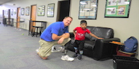 Young Boy With Prosthetic Leg Posing With Man With Prosthetic Leg