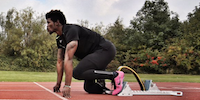 Athlete with Prosthetic Leg On Starting Blocks