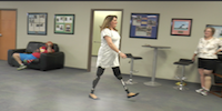 Woman Double Amputee Walking In Prosthetic Limbs During Therapy