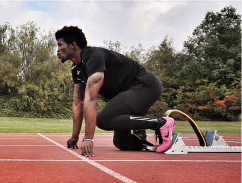 Runner With Prosthetic Leg In Ready Position At Starting Line